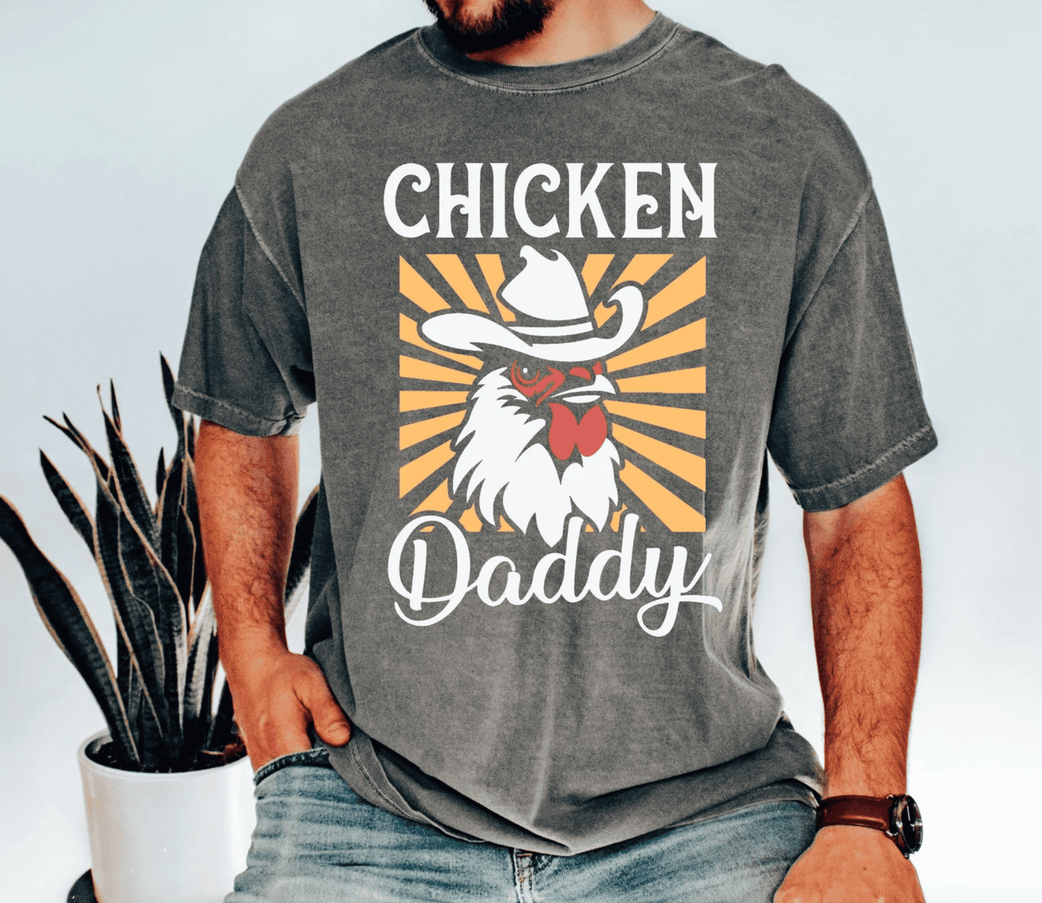 a man wearing a grey t-shirt that says, chicken daddy on the front